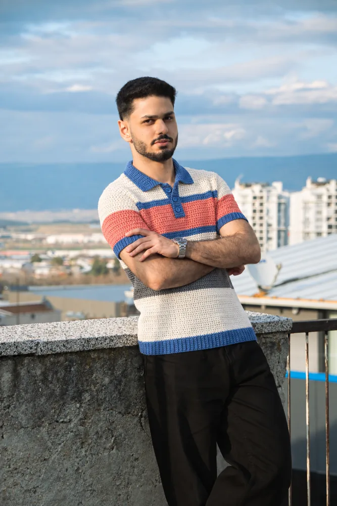 Model wearing the striped Breakwater crochet polo